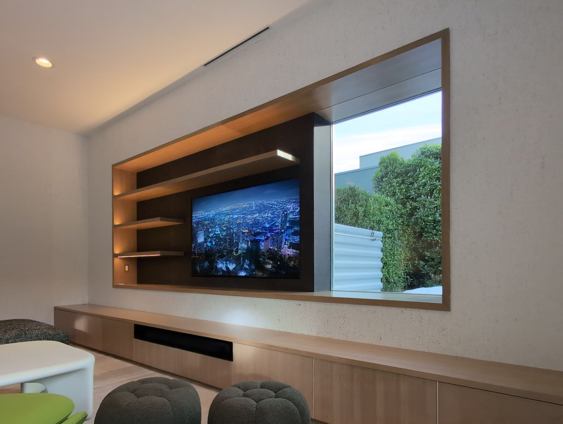 Palm Springs Living & Kitchen Remodel — entertainment wall detail with LED-lit floating shelves, TV niche, and pass-through window to garden
