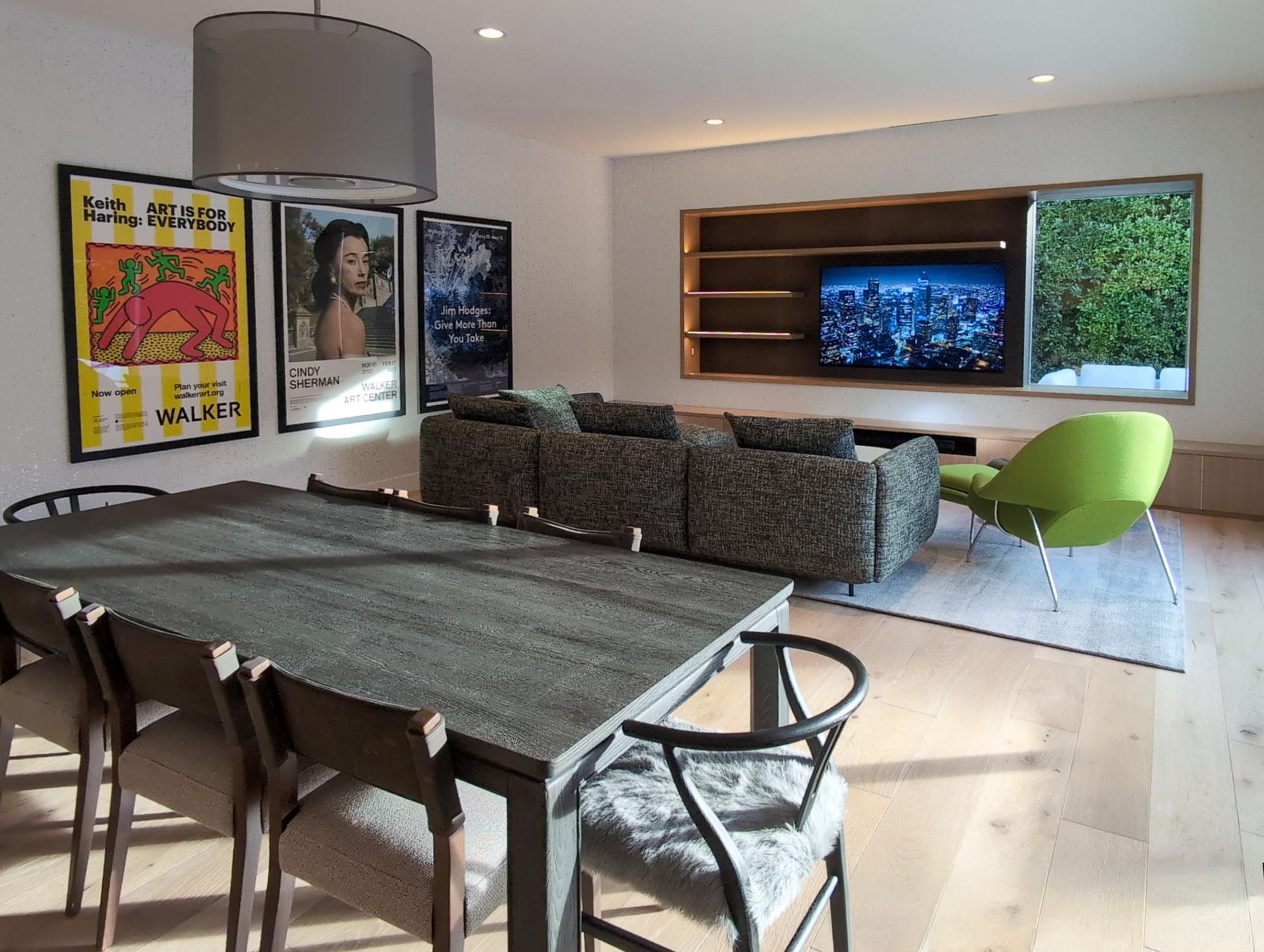 Palm Springs Living & Kitchen Remodel — open-plan great room with dining area, museum poster wall, sofa and custom entertainment wall