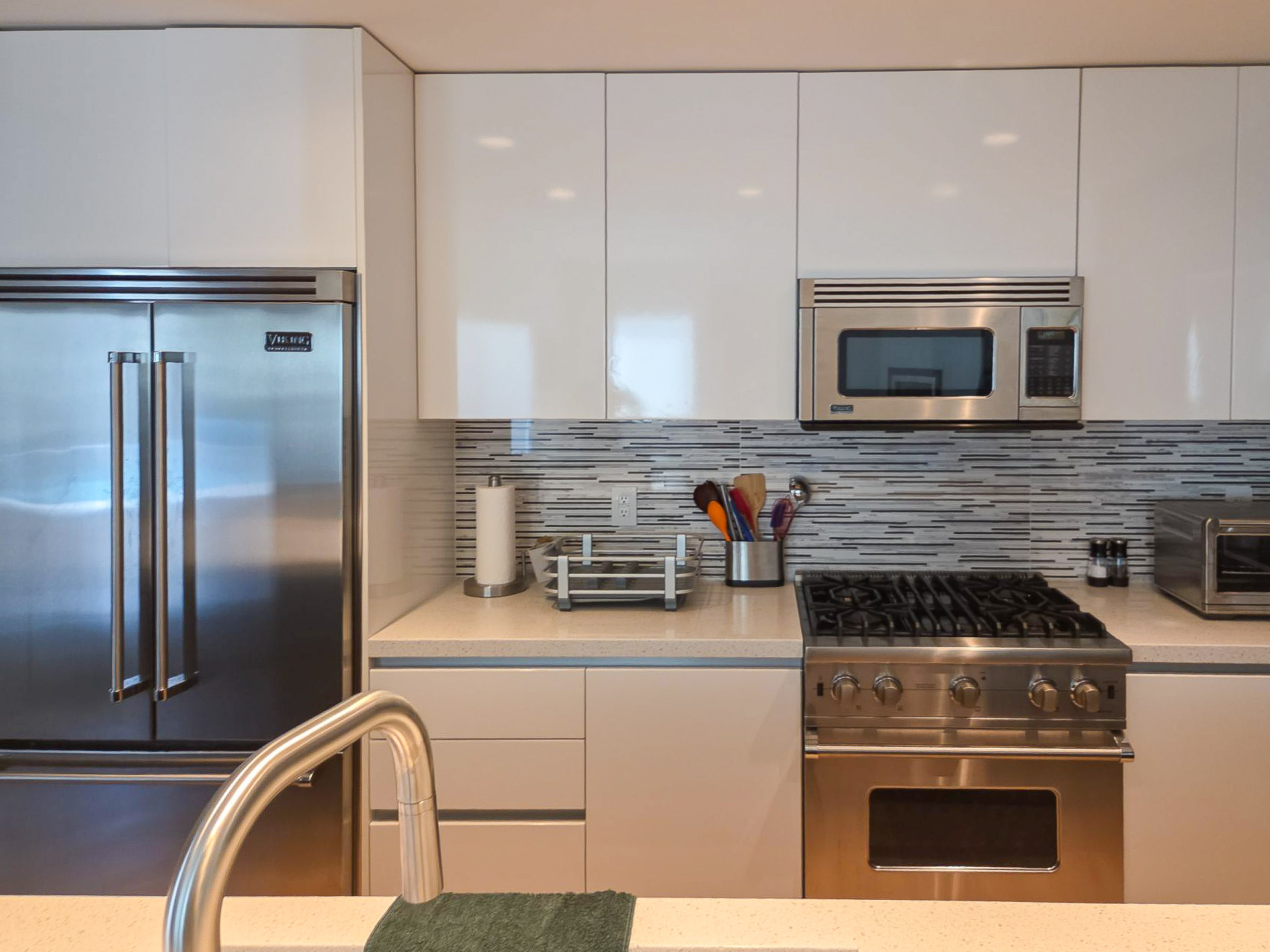 Palm Springs Living & Kitchen Remodel — kitchen cook zone with Viking range, mosaic tile backsplash, white upper cabinets and quartz countertops