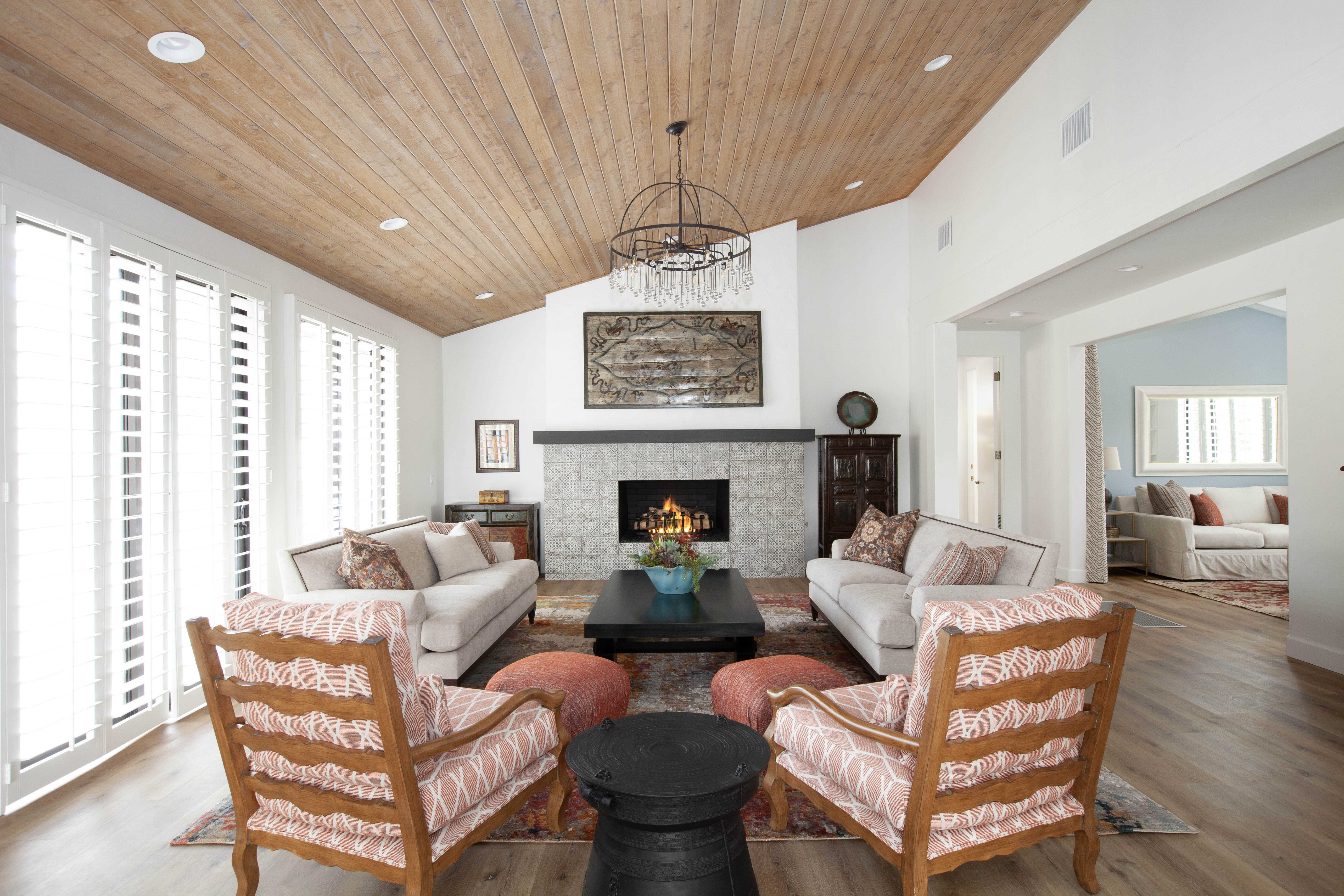 Room Addition & Whole-Home Renovation — living room with custom wood plank ceiling and lit fireplace
