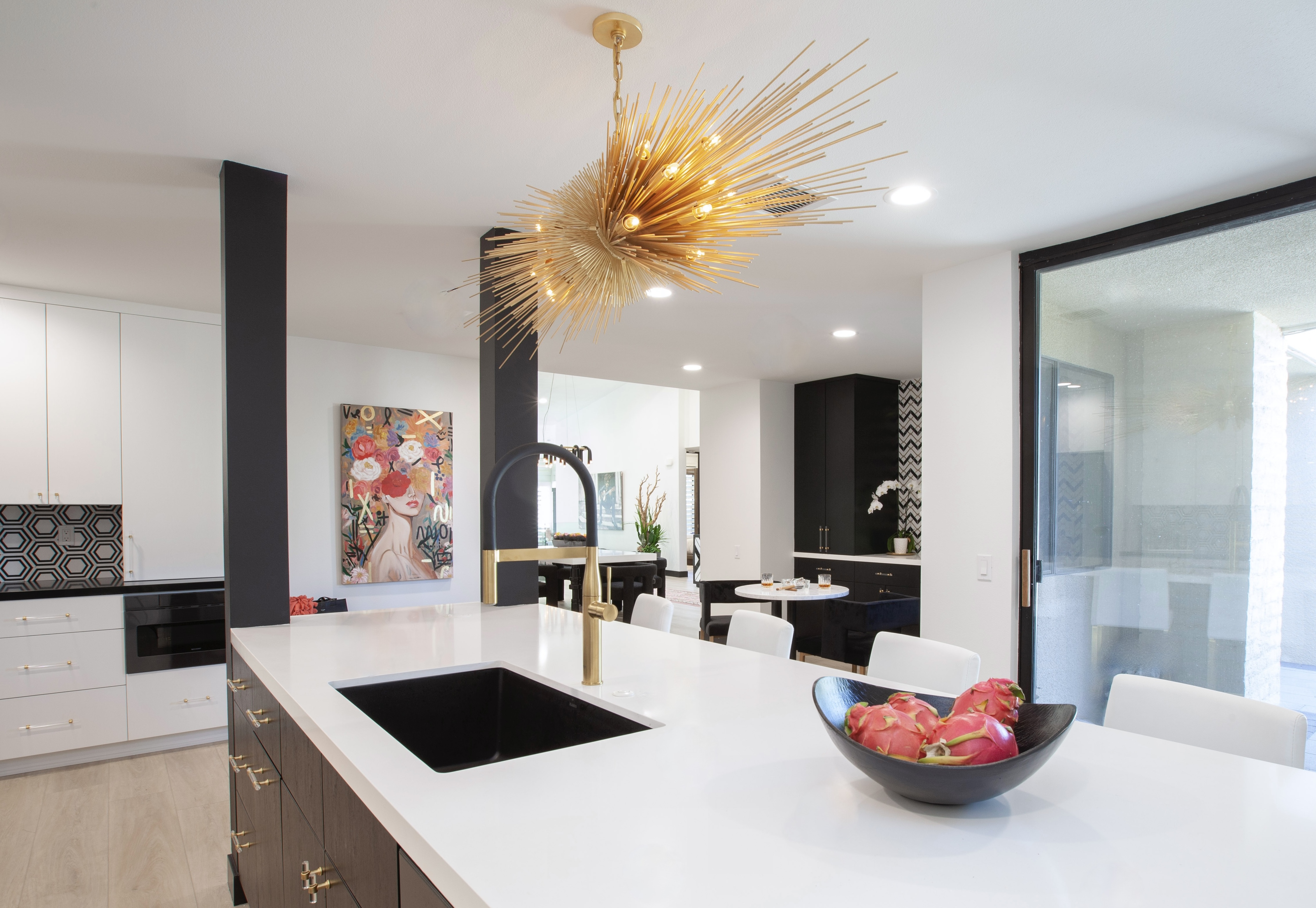 Desert Horizons Residence — kitchen with gold sputnik chandelier, long white island with sink