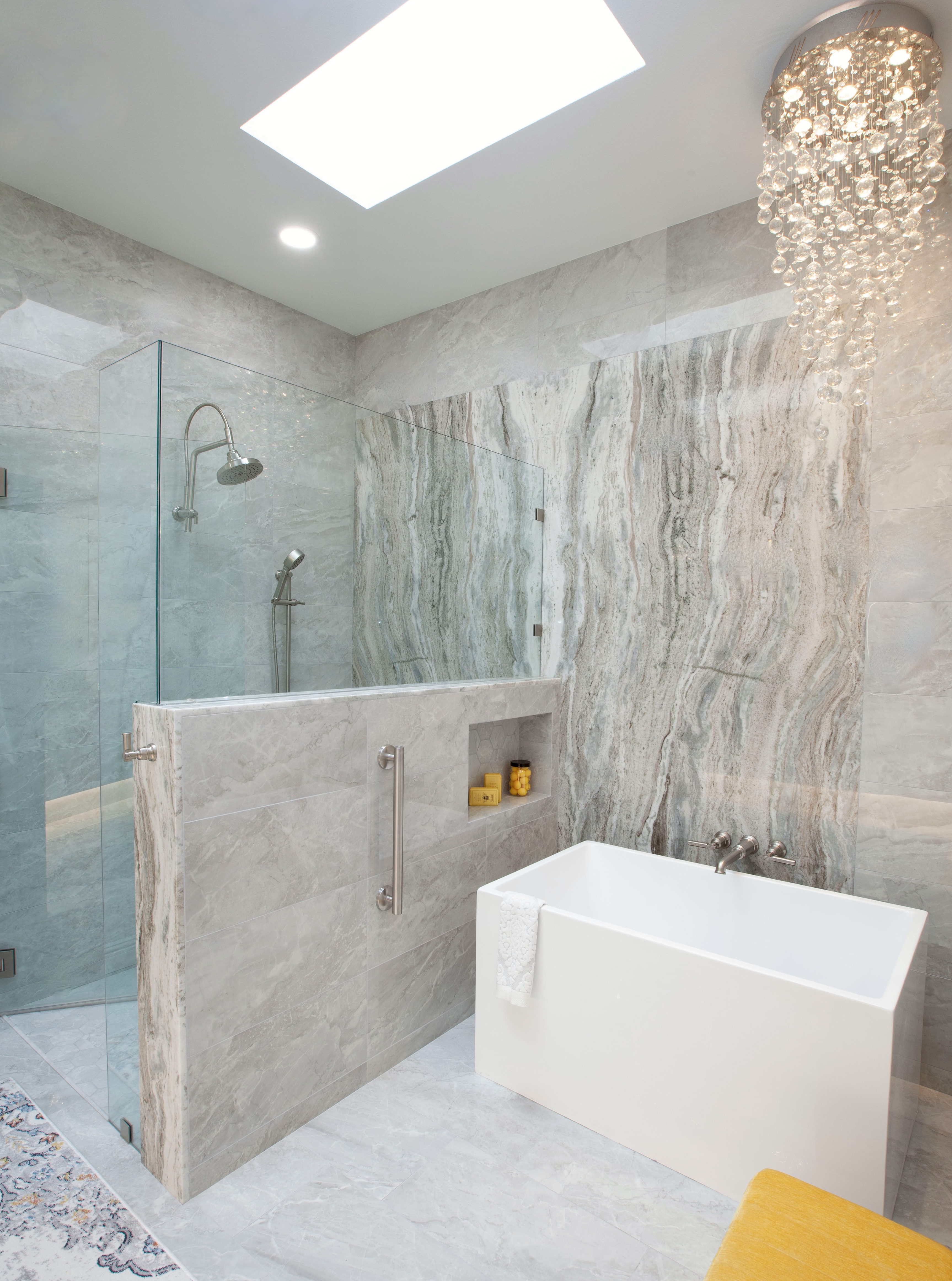 Multi-Bathroom Renovation — dramatic master bath with marble walls, skylight, glass shower and freestanding tub