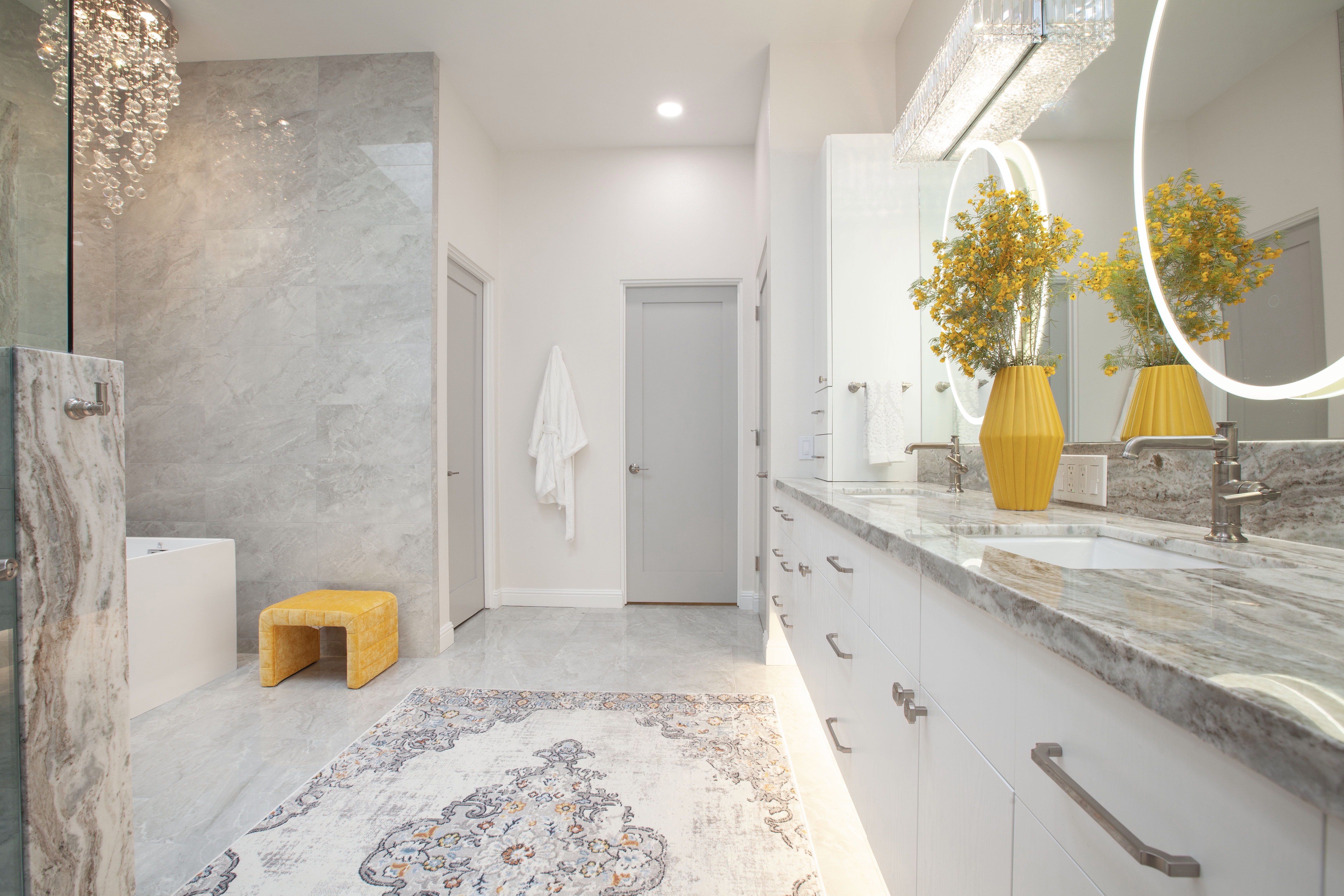 Multi-Bathroom Renovation — large master bath with yellow vases, marble counters, dual lit mirrors